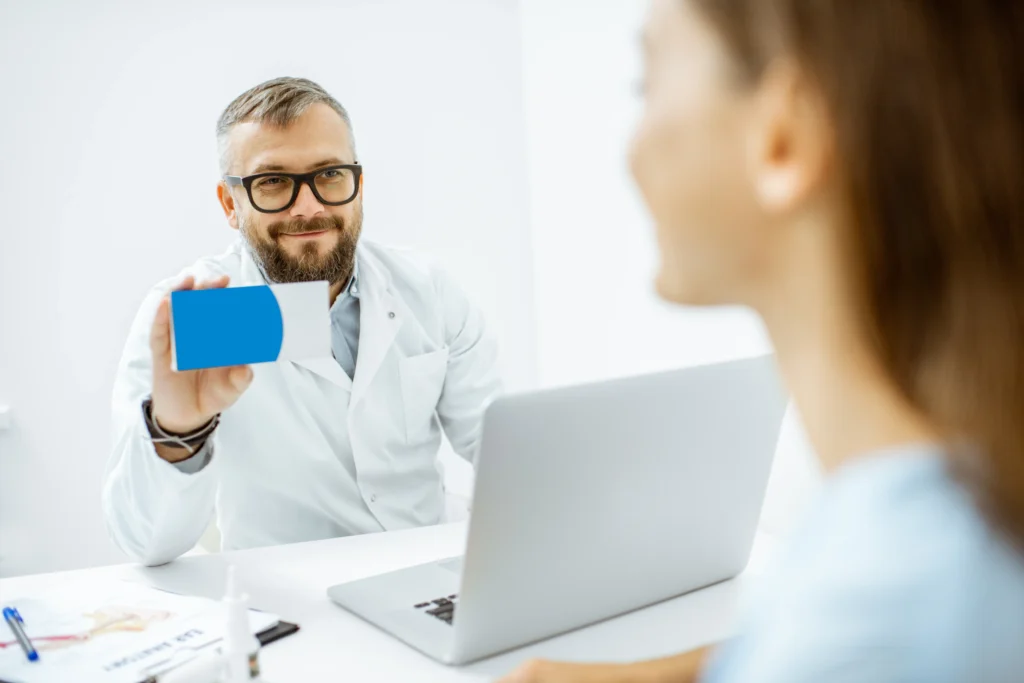 doctor showing medication box to patient in office 2026 03 24 05 27 51 utc